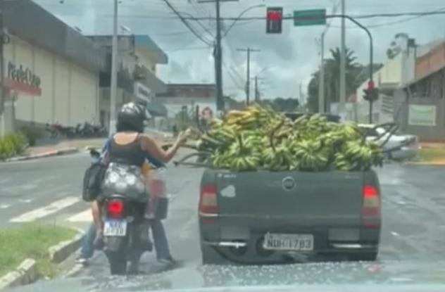 No Acre, mulher é flagrada pegando bananas da carroceria de carro parado no semáforo; veja