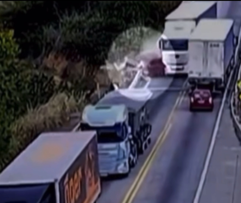 Caminhão desgovernado invade pista contrária, causa acidente grave e derruba carro de ponte