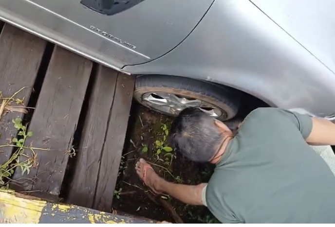 Madeira podre quebra, carro cai e fica enganchado na ponte entre os bairros Triângulo e Taquari